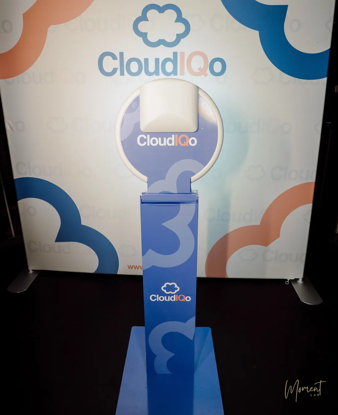 Photo booth fully wrapped in client branding, set in front of a matching branded backdrop