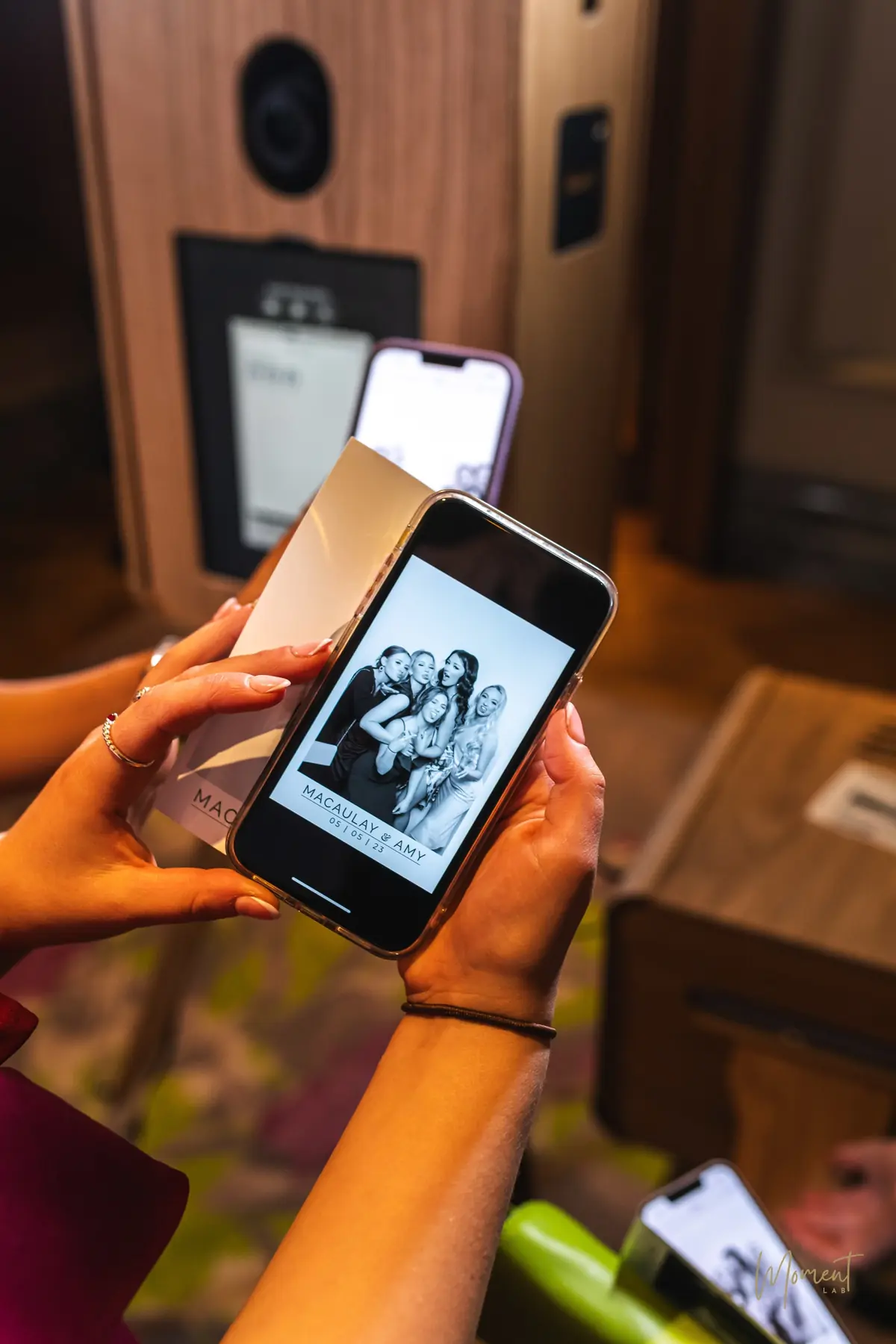 A guest holding her Glam print beside the same portrait on her phone