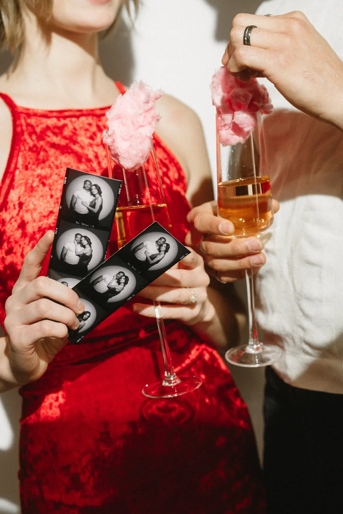 Guests toasting with champagne while holding their black and white Spotlight photo strips