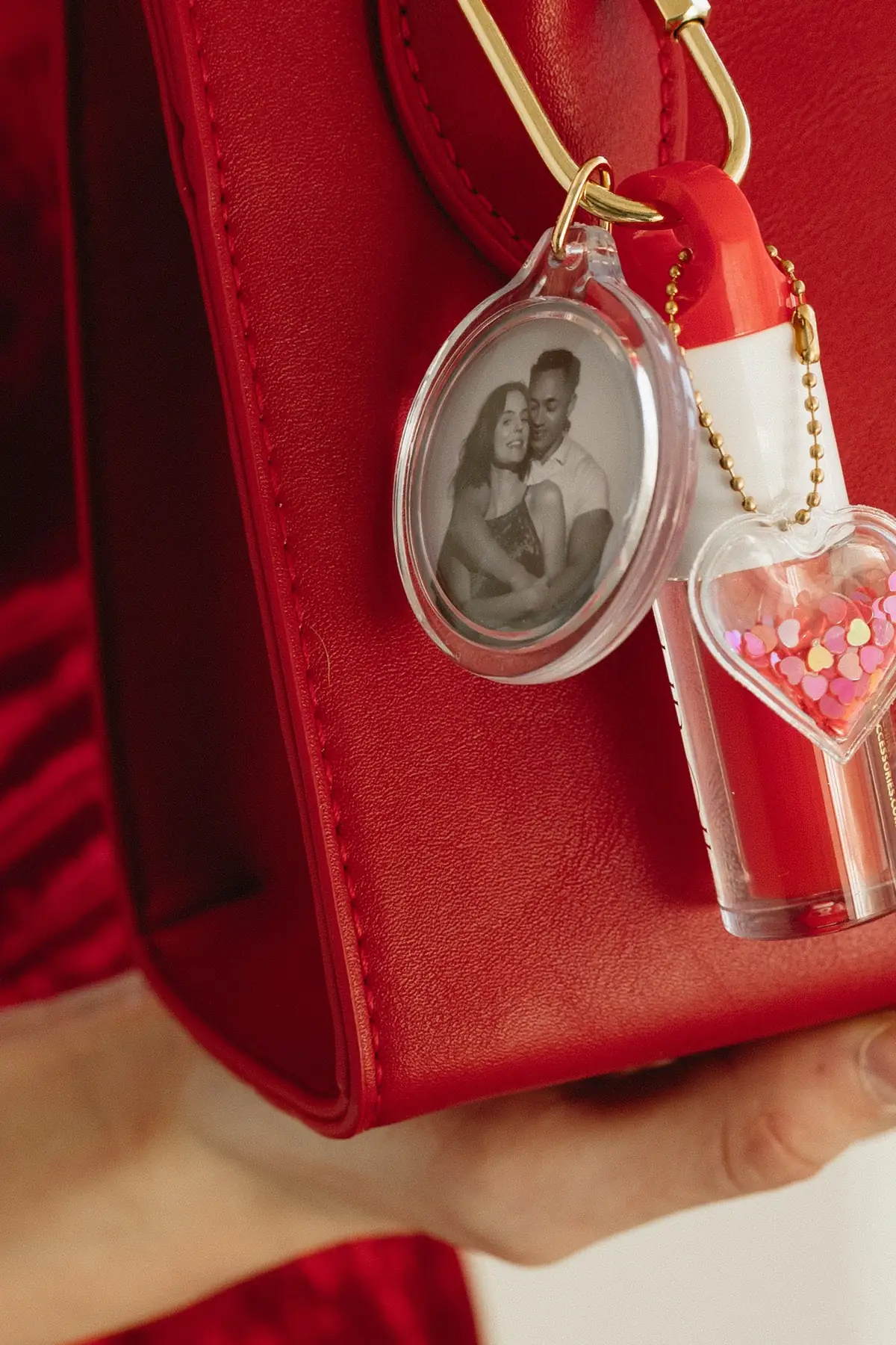 A black and white Spotlight portrait worn as a keyring on a red handbag