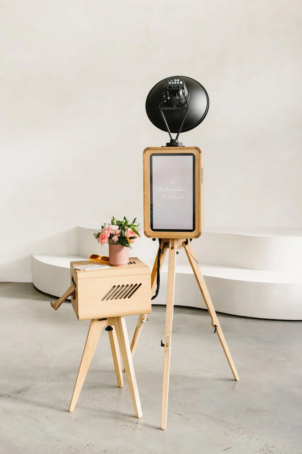 Oak photo booth with a studio light and matching printer stand, styled with fresh flowers